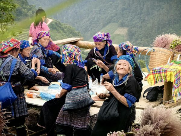 un groupe d'agricultrices Hmong à Mu Cang Chai se réunit pendant une pause