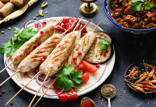 Kebab de poulet ou shish kebab avec légumes rôtis et sauce sur fond sombre